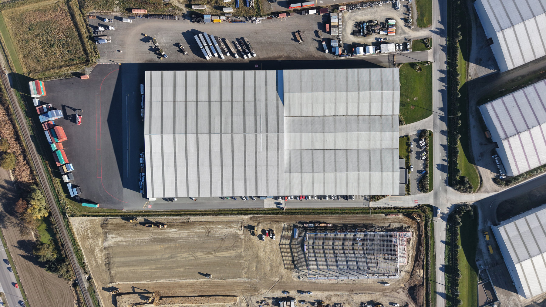 Top-down view of industrial roofs and a transport yard